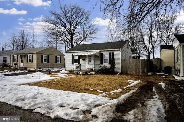 a view of a house with snow on the side of the road