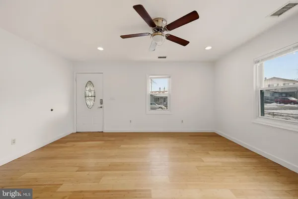 an empty room with a window and ceiling fan