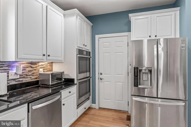 a view of a dining room and livingroom with furniture wooden floor a chandelier