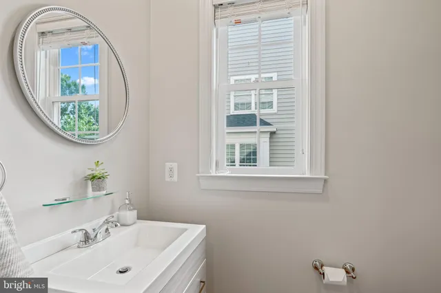 a view of staircase with lots of frames on wall and a window