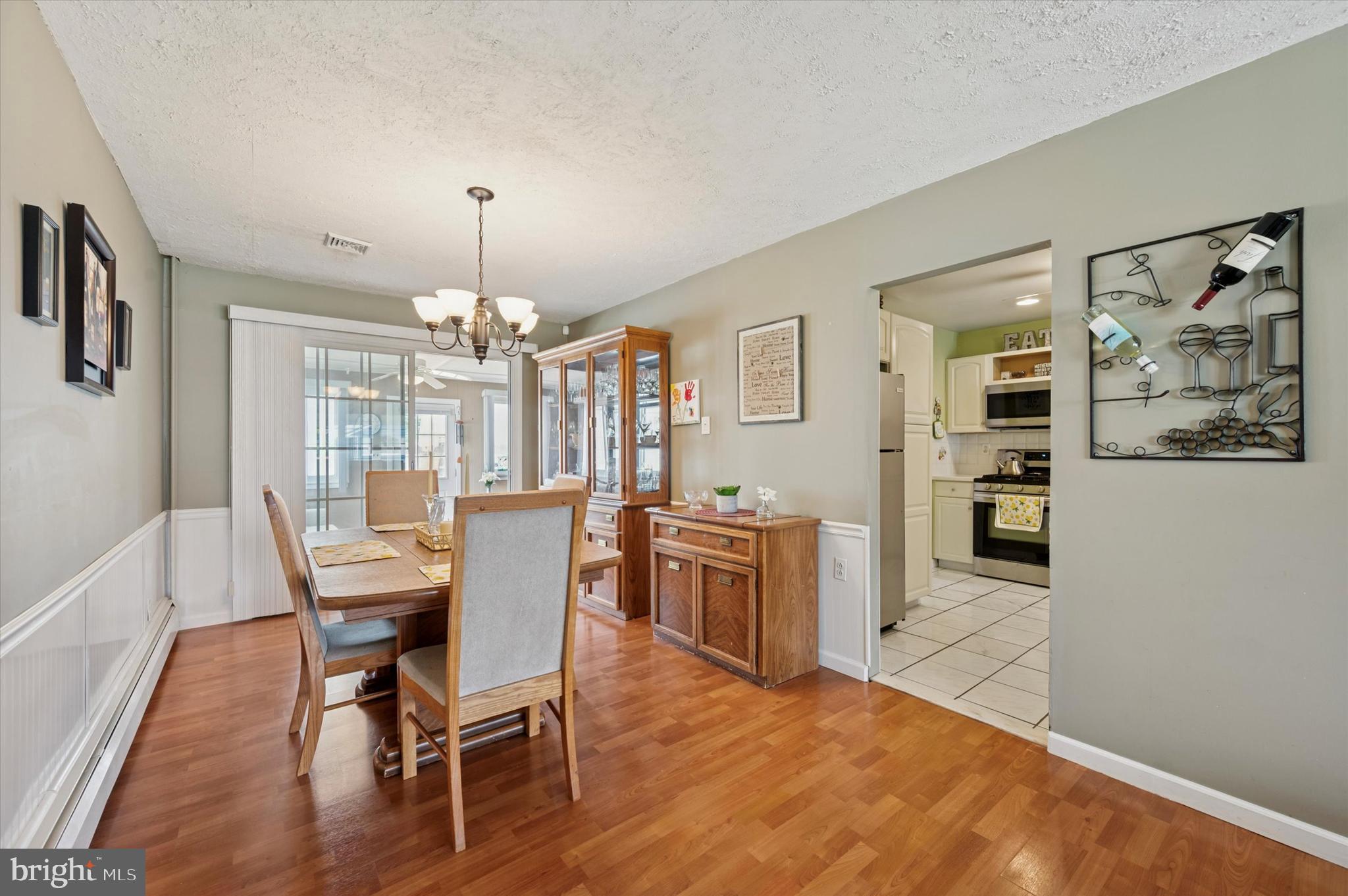 15 Paul Road Maple Shade, NJ 08052 - Photo 7 of 26 a dining room with wooden floor a chandelier a wooden table and chairs