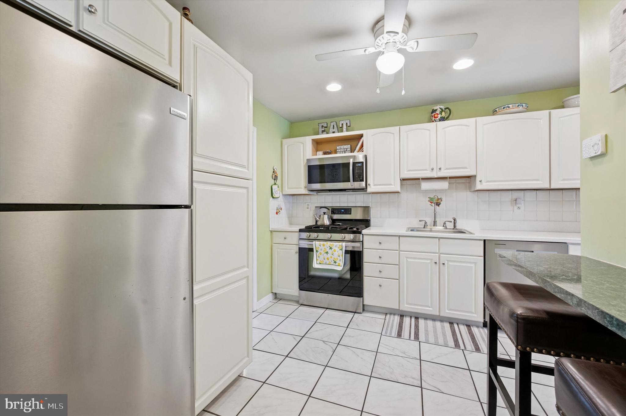 15 Paul Road Maple Shade, NJ 08052 - Photo 9 of 26 a kitchen with stainless steel appliances granite countertop a refrigerator a sink dishwasher a stove and white cabinets with wooden floor