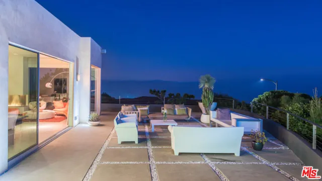 a living room with furniture a flat screen tv and a potted plant