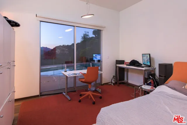 a bedroom with a bed and large window