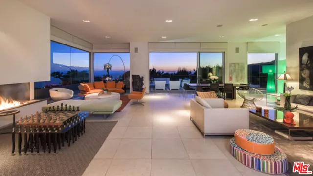 a living room with furniture kitchen view and a large window