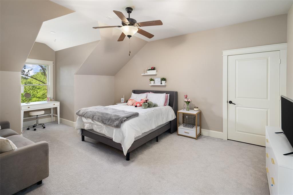 1814 Stacy Road Fairview, TX 75069 - Photo 20 of 36 a bedroom with a bed a couch and a chandelier