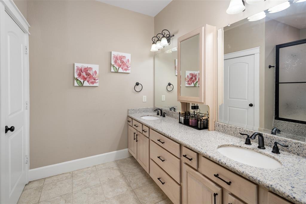 1814 Stacy Road Fairview, TX 75069 - Photo 21 of 36 a bathroom with a granite countertop double vanity sink a mirror and shower