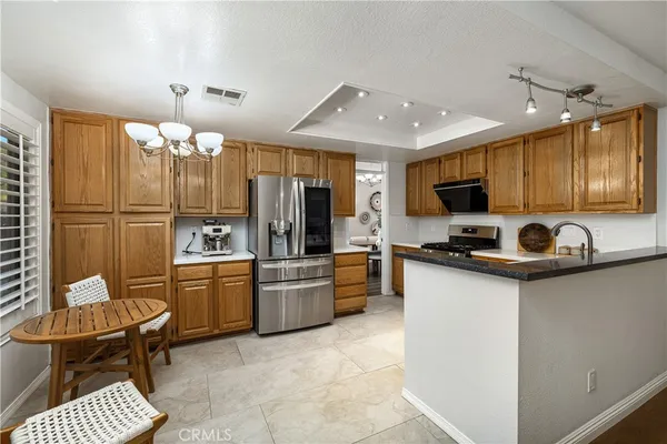 a kitchen with stainless steel appliances granite countertop a refrigerator stove and sink