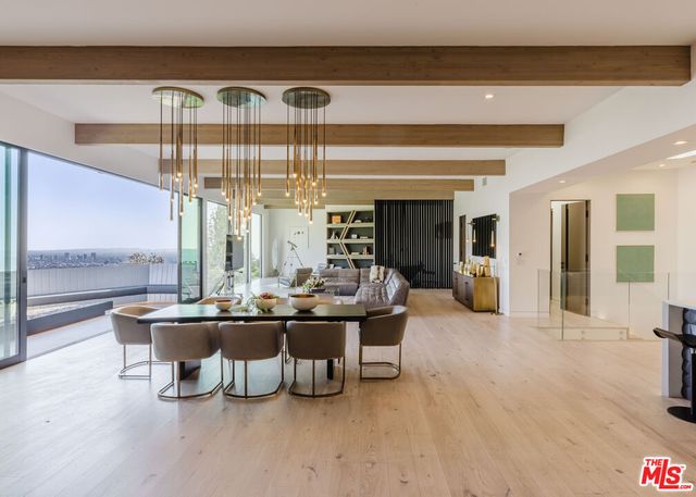 a living room with furniture a chandelier and a large window