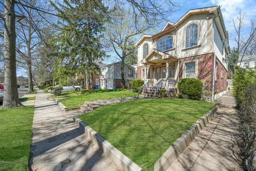 187-11 Aberdeen Road Queens, NY 11432 - Photo 1 of 1 View of front of house with a front yard, stucco siding, and brick siding