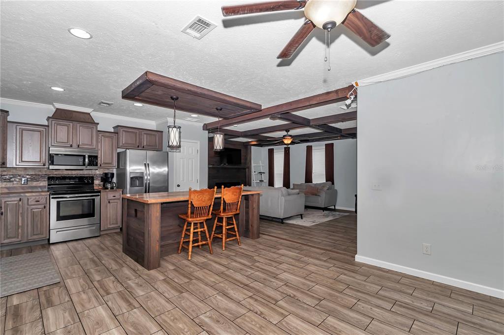 7565 Dewey Robbins Road Howey-in-the-Hills, FL 34737 - Photo 11 of 42 a kitchen with stainless steel appliances granite countertop a stove and a refrigerator