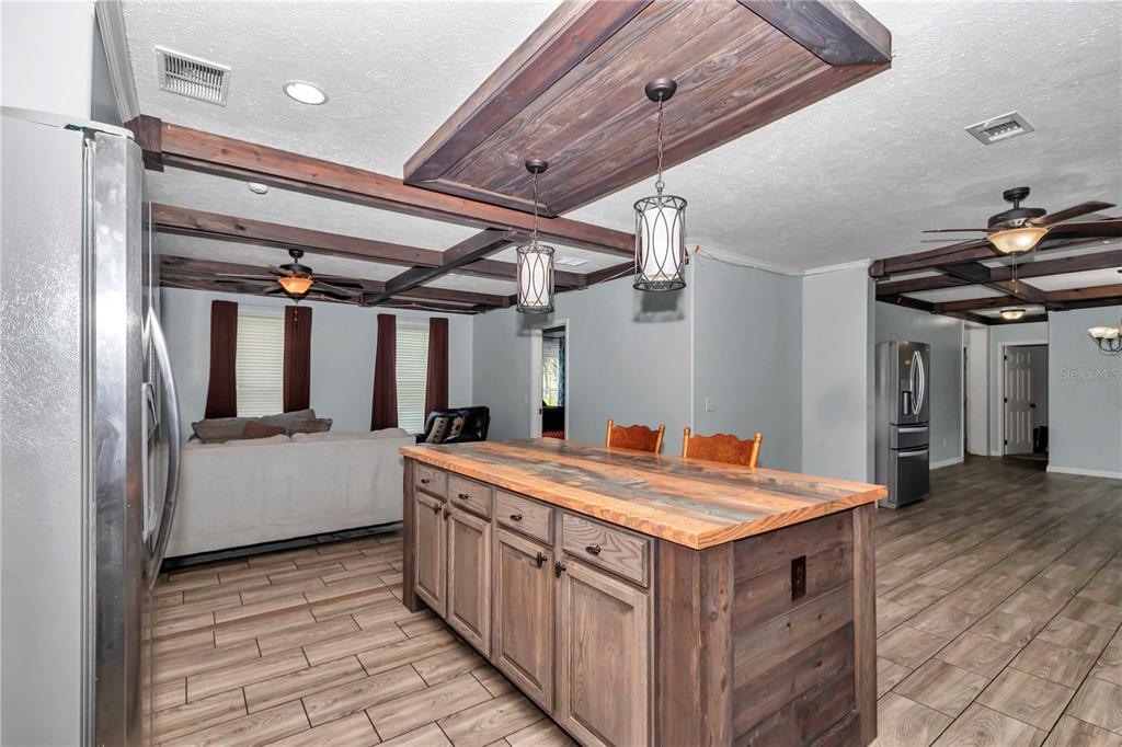 7565 Dewey Robbins Road Howey-in-the-Hills, FL 34737 - Photo 14 of 42 a utility room with stainless steel appliances granite countertop furniture and a wooden floor