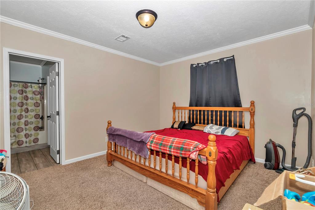 7565 Dewey Robbins Road Howey-in-the-Hills, FL 34737 - Photo 22 of 42 a bedroom with a bed and a window