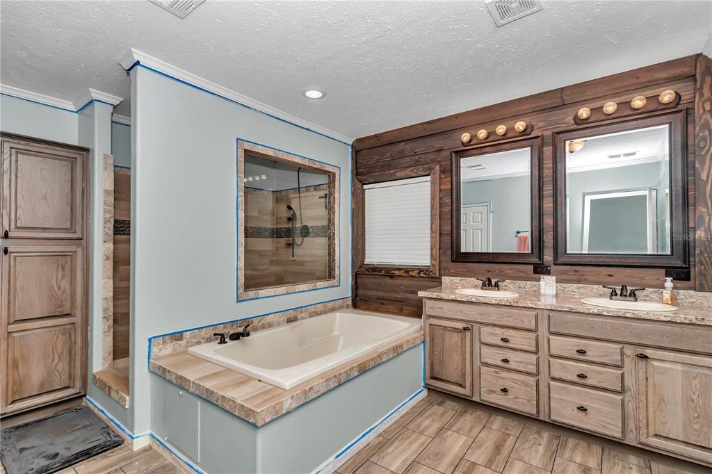 7565 Dewey Robbins Road Howey-in-the-Hills, FL 34737 - Photo 32 of 42 a bathroom with a tub sink and mirror