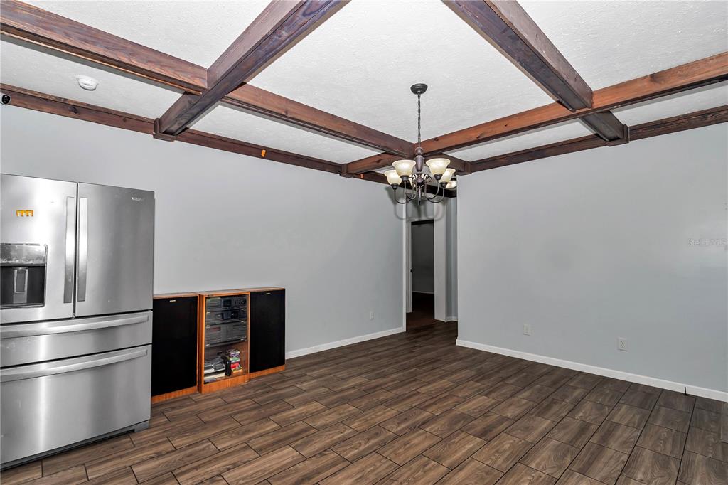 7565 Dewey Robbins Road Howey-in-the-Hills, FL 34737 - Photo 9 of 42 a view of a kitchen with stainless steel appliances wooden floor and a refrigerator