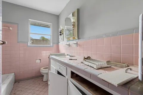 a bathroom with a granite countertop toilet sink and mirror