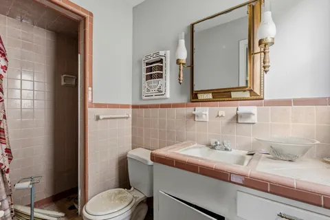 a bathroom with a sink a toilet and mirror