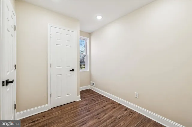an empty room with wooden floor chandelier fan and windows