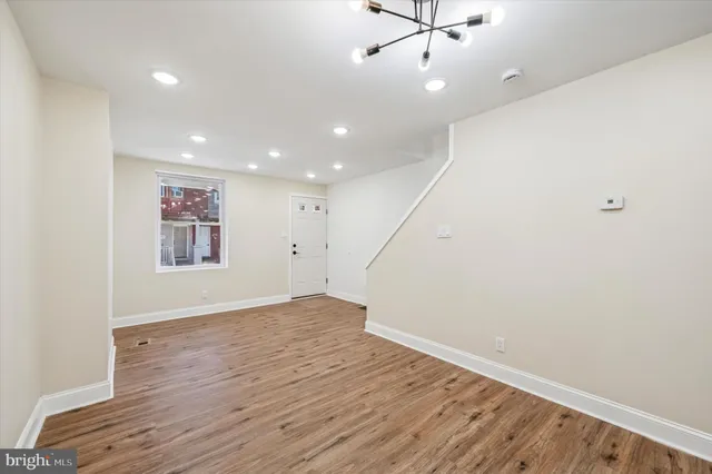 an empty room with wooden floor and ceiling fan