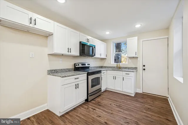 a kitchen with stainless steel appliances granite countertop a stove a sink and a refrigerator