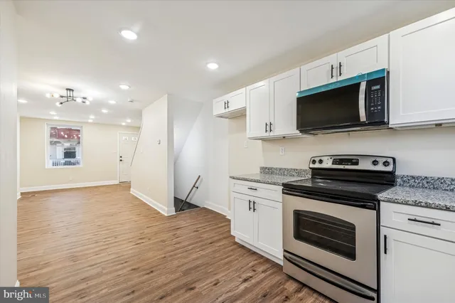 a kitchen with stainless steel appliances kitchen island granite countertop a stove a sink and a microwave