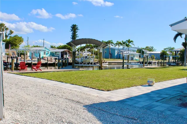 a kitchen with stainless steel appliances kitchen island granite countertop a table chairs stove and refrigerator
