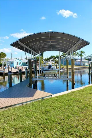 a kitchen with stainless steel appliances granite countertop a sink a stove a refrigerator cabinets and a dining table