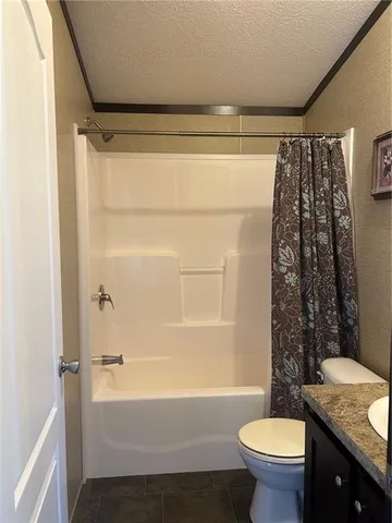 a bathroom with a granite countertop toilet sink and mirror