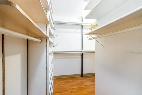 a view of walk in closet with empty racks