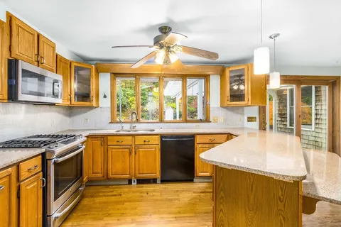 a kitchen with stainless steel appliances granite countertop a stove a sink and a refrigerator