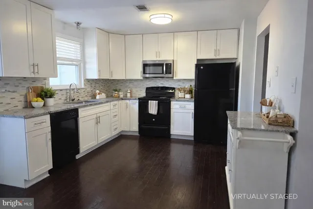a kitchen with granite countertop a refrigerator stove and sink