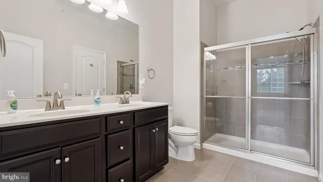 a bathroom with a double vanity sink mirror and toilet