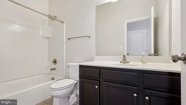 a bathroom with a toilet a sink a mirror a bathtub and vanity