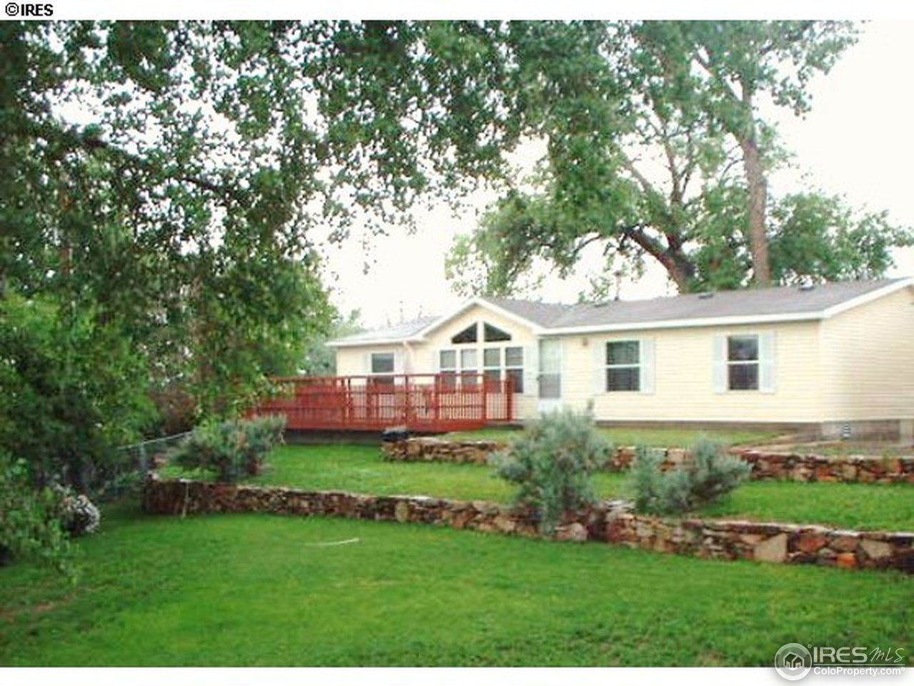 108 East Douglas Road Fort Collins, CO 80524 - Photo 1 of 12 a front view of a house with a garden and trees