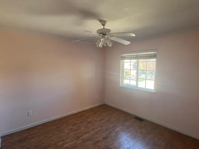 an empty room with a window and a fan