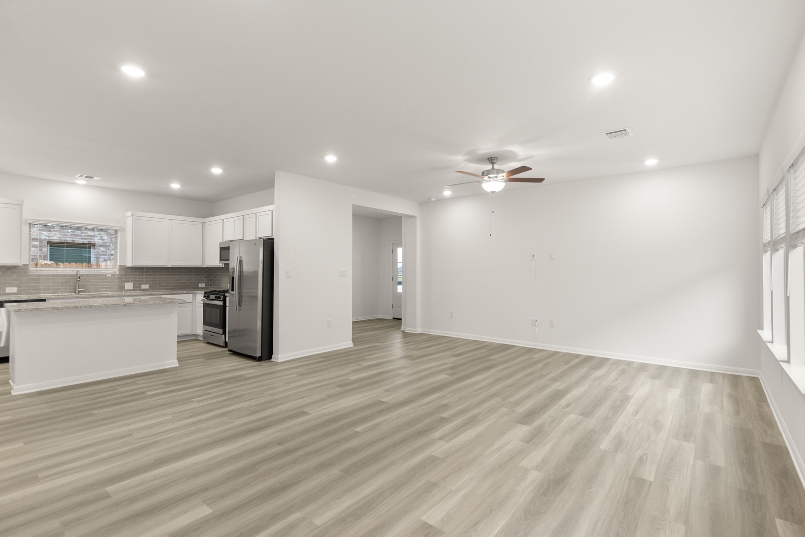 18605 Emu Lane Manor, TX 78653 - Photo 8 of 27 Open concept living space featuring light-toned flooring, recessed lighting, and a modern ceiling fan