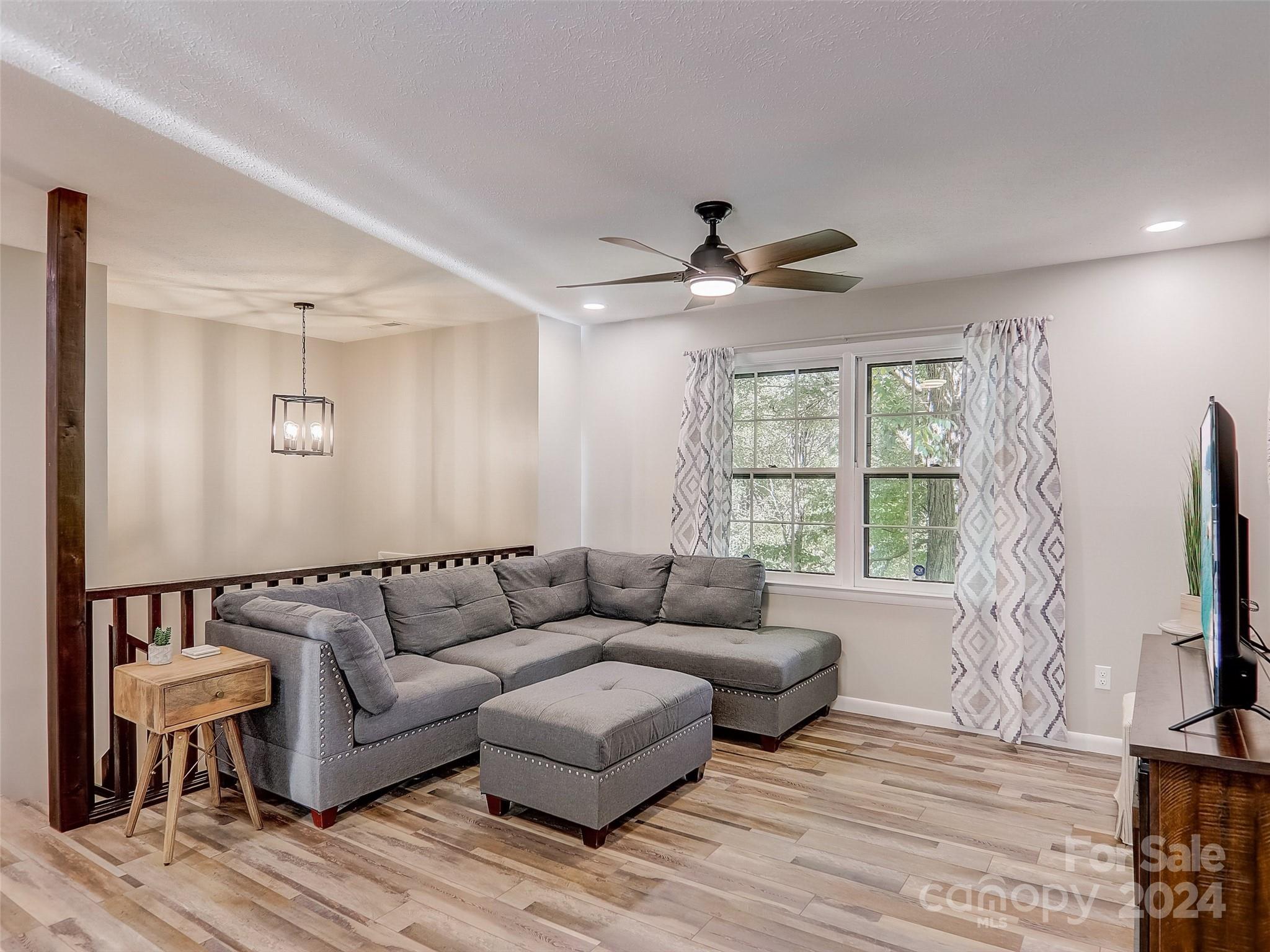 1191 Dupont Road Hendersonville, NC 28739 - Photo 11 of 48 a living room with furniture flat screen tv and a large window