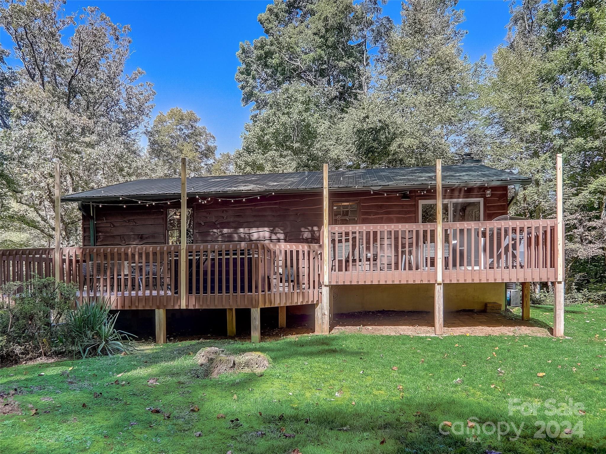 1191 Dupont Road Hendersonville, NC 28739 - Photo 31 of 48 a view of a house with a deck and a yard with wooden fence