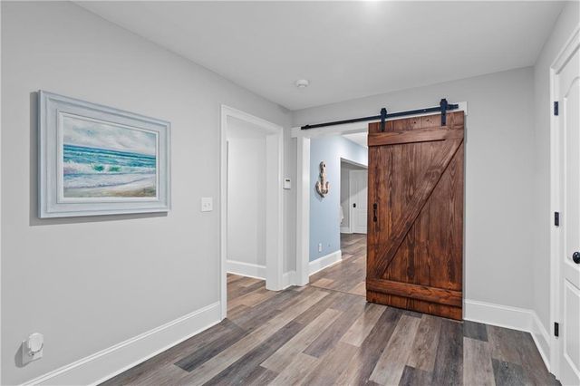 a room with table two windows and wooden floor