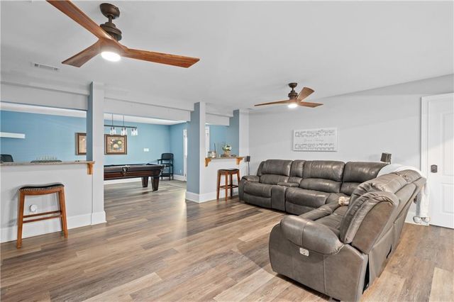 a living room with furniture a flat screen tv and gym equipment