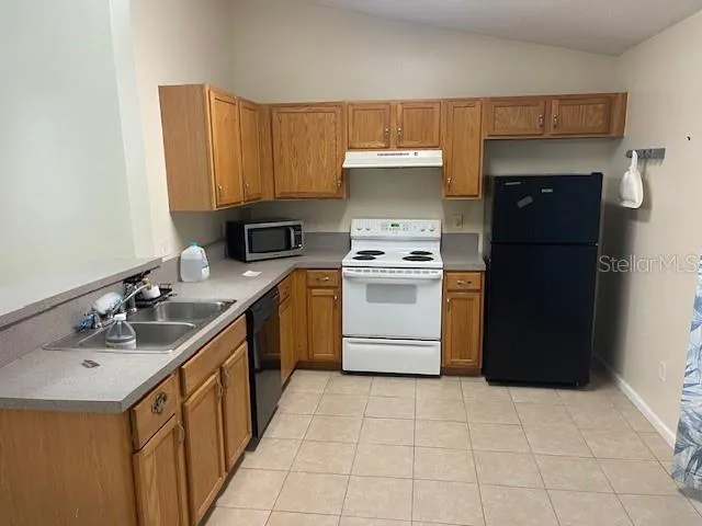 a kitchen with a sink appliances and cabinets