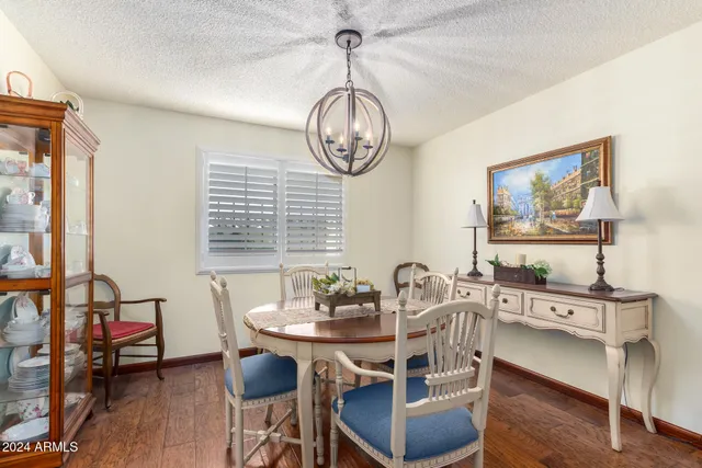 a dining room with furniture a chandelier and wooden floor