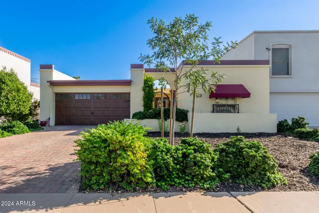 a front view of a house with plants