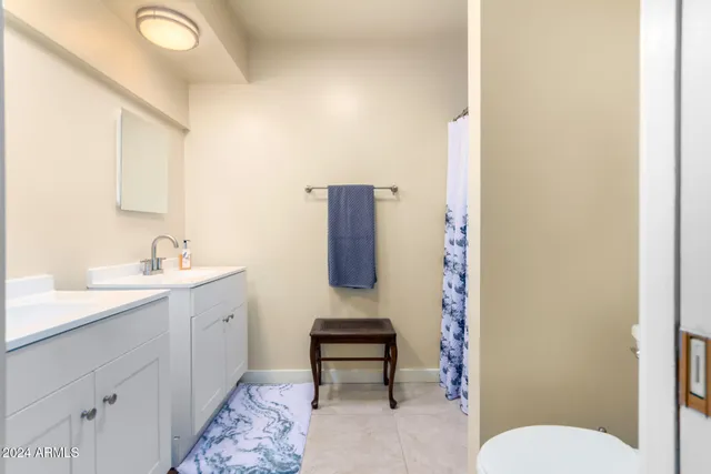 a bathroom with a toilet sink a mirror and vanity