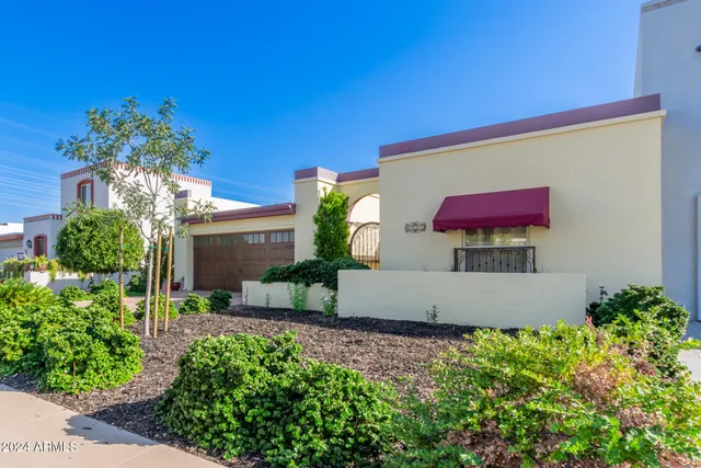 a view of a house with a yard and potted plants