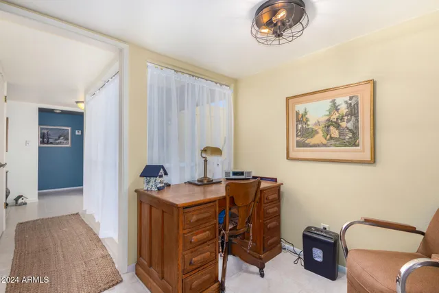 a view of a workspace with furniture and a window