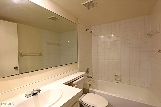 a bathroom with a bathtub shower sink vanity and toilet