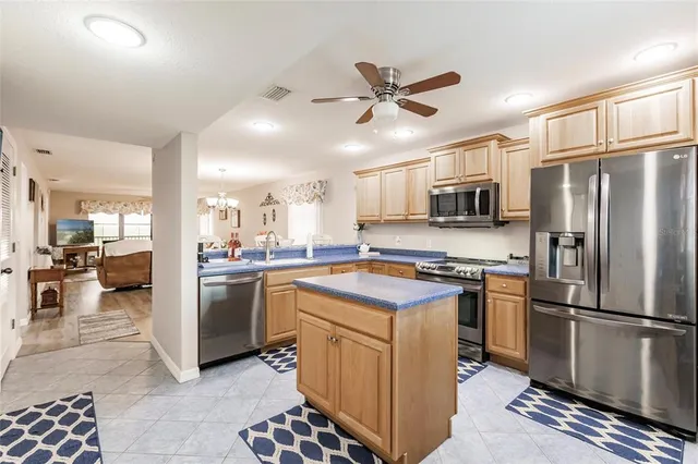 a kitchen with stainless steel appliances granite countertop a refrigerator a stove a sink a oven with white cabinets and wooden floor