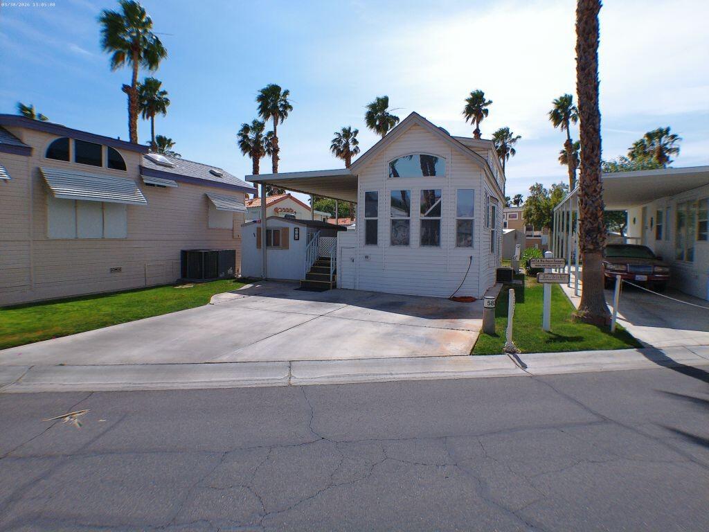 84136 Ave 44, Unit 582 Indio, CA 92203 - Photo 2 of 56 a front view of a house with a yard and potted plants