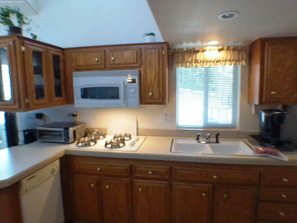 84136 Ave 44, Unit 582 Indio, CA 92203 - Photo 23 of 56 a kitchen with a sink wooden cabinets and a window